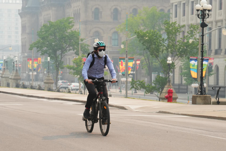 A cyclist wears a mask due to poor air quality conditions as smoke from wildfires in Ontario and Quebec hangs over Ottawa on Tuesday, June 6, 2023. THE CANADIAN PRESS/Sean Kilpatrick