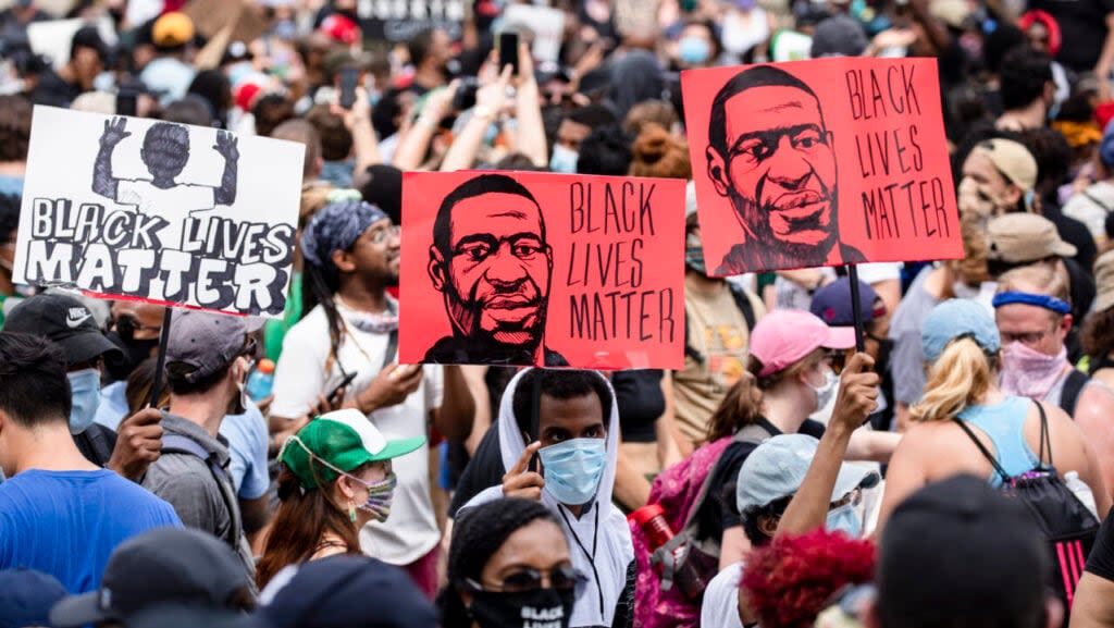 Protesters walk along the recently renamed Black Lives Matter Plaza with signs near the White House during George Floyd protests on June 6, 2020 in Washington, D.C. (Photo by Samuel Corum/Getty Images)