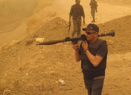 Armed Shi'ite volunteers from brigades loyal to radical cleric Muqtada al-Sadr, take their positions during a military advance in areas under the control of militants of the Islamic State, formerly known as the Islamic State in Iraq and the Levant (ISIL), on the outskirts of Samarra July 13, 2014. REUTERS/Stringer