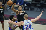 Cleveland Cavaliers' Isaac Okoro (35) passes against Detroit Pistons' Mason Plumlee (24) and Detroit Pistons' Saddiq Bey (41) in the first half of an NBA basketball game, Wednesday, Jan. 27, 2021, in Cleveland. (AP Photo/Tony Dejak)