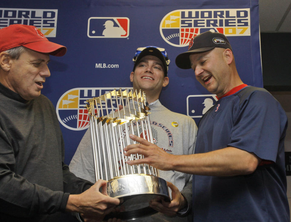 FILE - Boston Red Sox president Larry Lucchino, left, general manager Theo Epstein, center, and manager Terry Francona hold the World Series trophy after Boston beat the Colorado Rockies, 4-3, in Game 4 Sunday, Oct. 28, 2007, at Coors Field in Denver, to sweep the series 4-0. Slowed by major health issues in recent years, the personable, popular Francona may be stepping away, but not before leaving a lasting imprint as a manager and as one of the game's most beloved figures.(AP Photo/David J. Phillip, FIle)