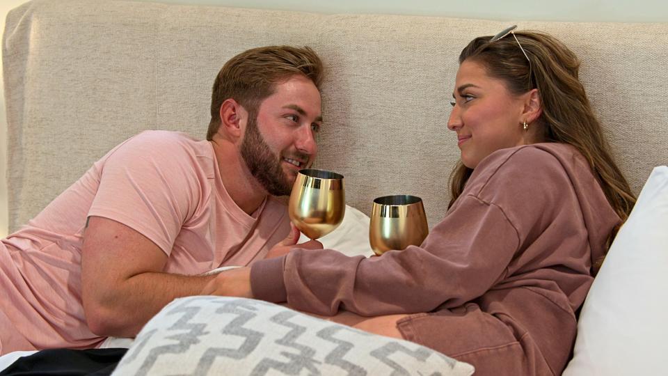 Matt and Colleen drinking on a bed