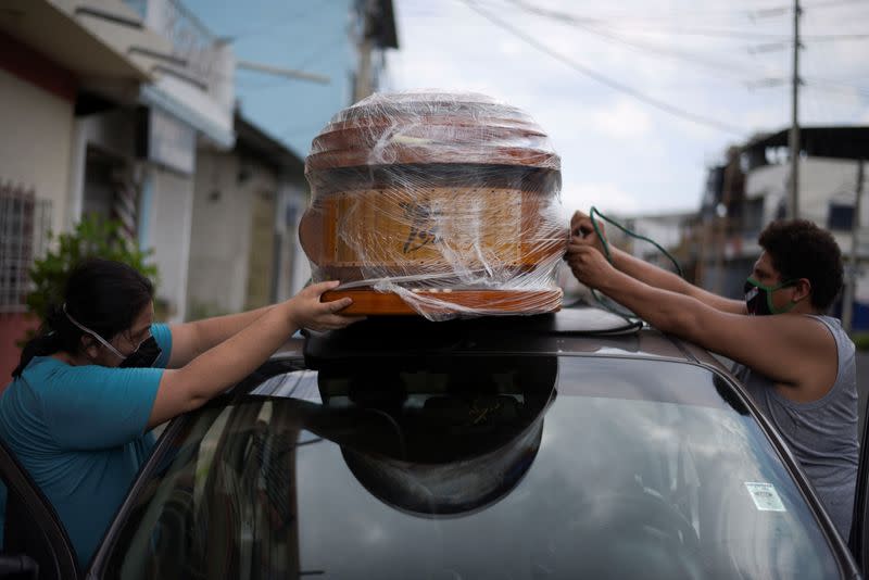 A couple ties an empty coffin to their car to collect the body of a relative as Ecuador's government announced on Thursday it was building a "special camp" in Guayaquil for coronavirus disease (COVID-19) victims, in Guayaquil