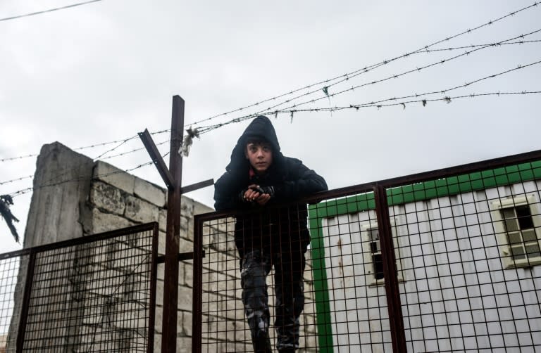 A boy on a fence in Bab-Al Salam near the Turkish border on February 6, 2016 as Syrians flee Aleppo