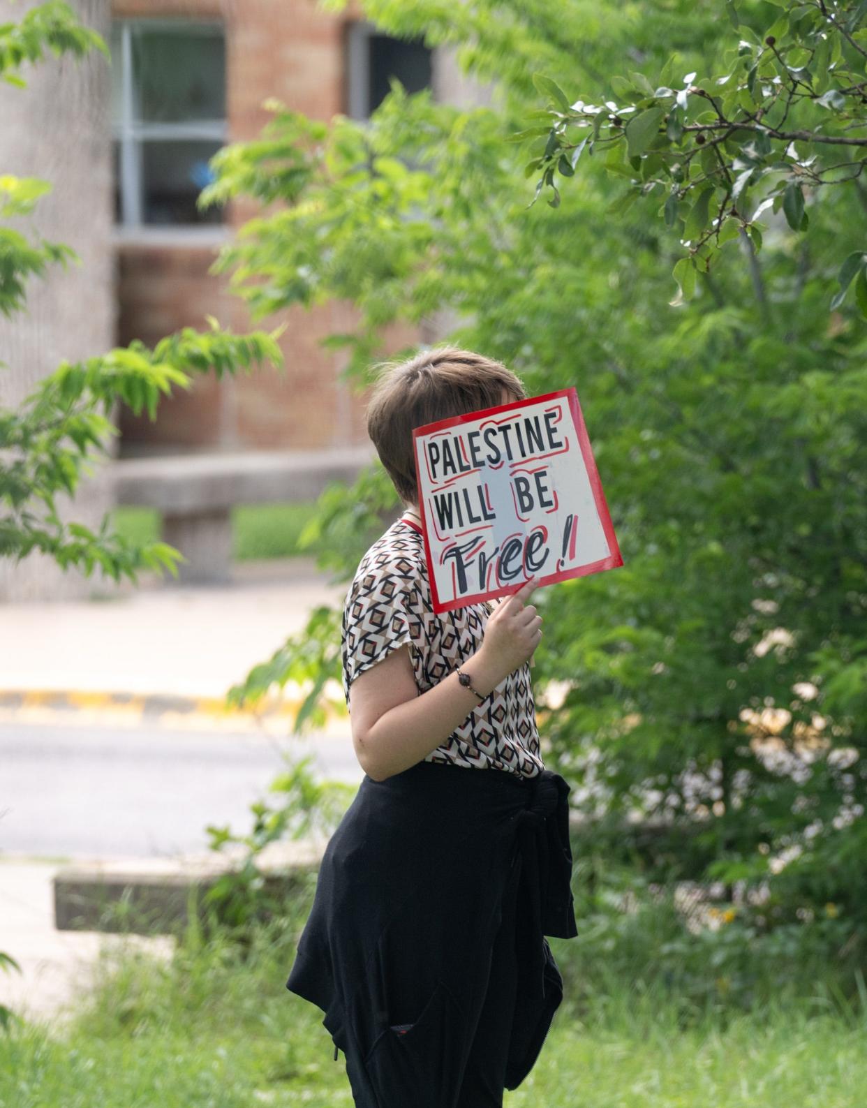 A student holds a sign as students participate in a walk-out during a pro-Palestenian protest at McCallum High School Monday, April 29, 2024.