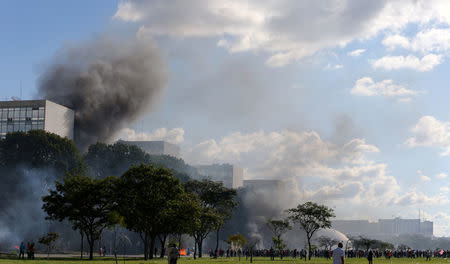 Smoke rises near the building of the Agriculture Ministry during a protest against Brazilian President Michel Temer and the latest corruption scandal to hit the country, in Brasilia, Brazil May 24, 2017. REUTERS/Paulo Whitaker