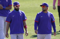 Texas Rangers' Isiah Kiner-Falefa, left, and Willie Calhoun walk between drills during spring training baseball practice Monday, Feb. 22, 2021, in Surprise, Ariz. (AP Photo/Charlie Riedel)