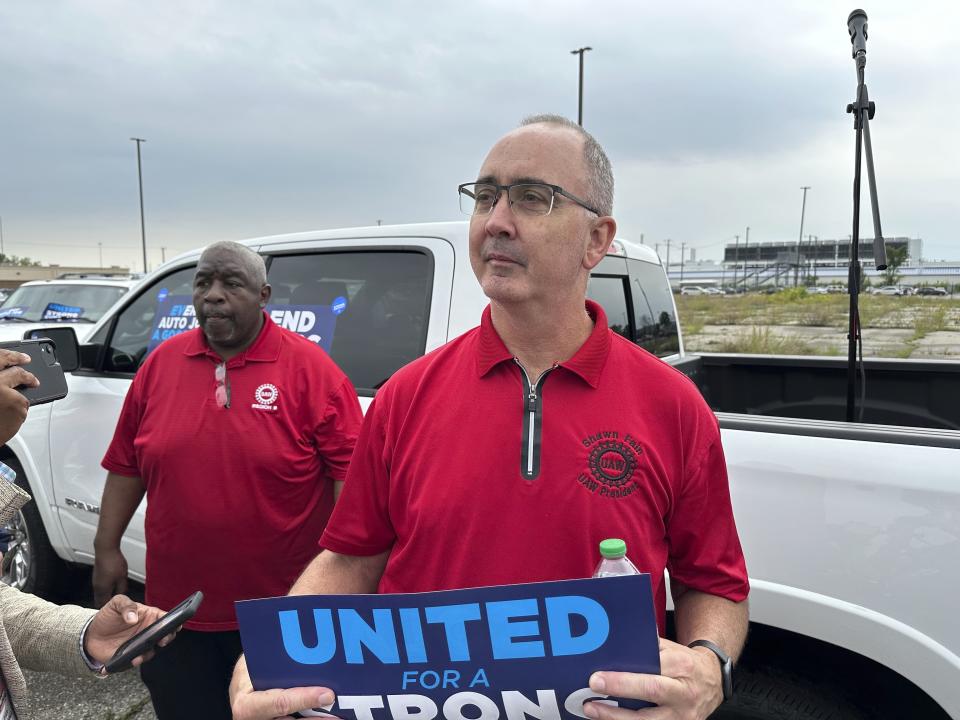 United Auto Workers President Shawn Fain holds up a sign at a union rally held near a Stellantis factory Wednesday, Aug. 23, 2023, in Detroit. Fain told reporters that bargaining on a new contract is not going well between the UAW and Detroit's three automakers. (AP Photo/Mike Householder)