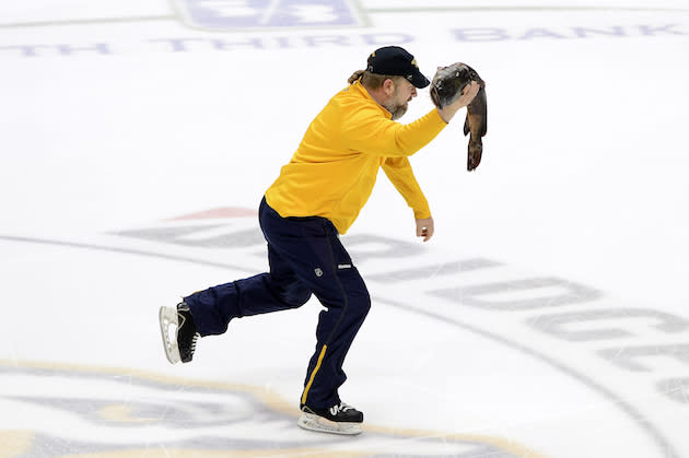 A Nashville Predators crew employee skates off the ice carrying a catfish before the start of Game 3 between the Anaheim Ducks and the Nashville Predators in an NHL hockey first-round Stanley Cup playoff series Tuesday, April 19, 2016, in Nashville, Tenn. (AP Photo/Mark Zaleski)