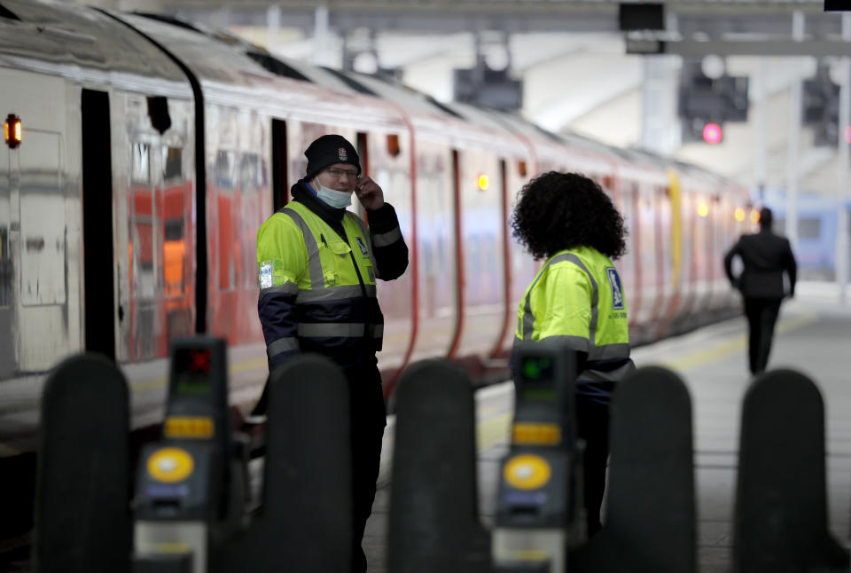 Station staff work at a quiet quiet Waterloo Station in London during rush hour, Wednesday, May 13, 2020, as the country continues in lockdown to help stop the spread of coronavirus. Some of the coronavirus lockdown measures are being relaxed in England on Wednesday, with those workers who are unable to work from home, such as those in construction and manufacturing, encouraged to return to work. (AP Photo/Kirsty Wigglesworth)