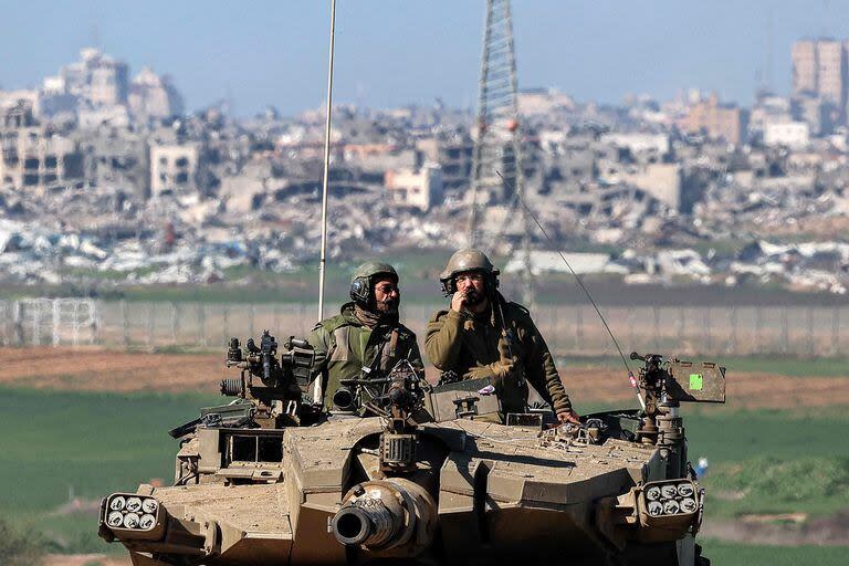 Soldados del ejército israelí sentados en la torre de un tanque de batalla que se mueve en una posición a lo largo de la frontera entre el sur de Israel y la Franja de Gaza el 31 de enero de 2024 en medio del conflicto en curso entre Israel y el grupo militante palestino Hamas.