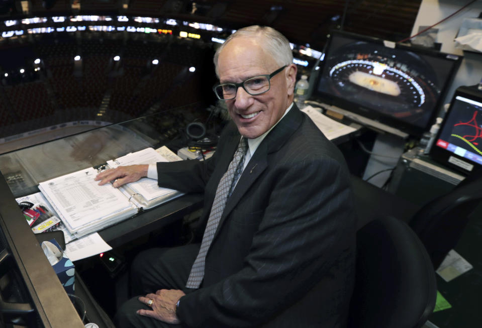 FILE - In this Wednesday, May 29, 2019, file photo, NBC hockey broadcaster Mike Emrick poses for a photo while preparing to call Game 2 of the NHL hockey Stanley Cup Final between the St. Louis Blues and the Boston Bruins, in Boston. Hall of Fame hockey broadcaster Mike Emrick is retiring after a career of almost 50 years behind the microphone, including the past 15 as the voice of the NHL in the United States. (AP Photo/Charles Krupa, File)