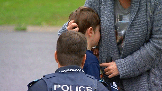 School student being comforted by police officer after finding their classroom had been damaged by fire