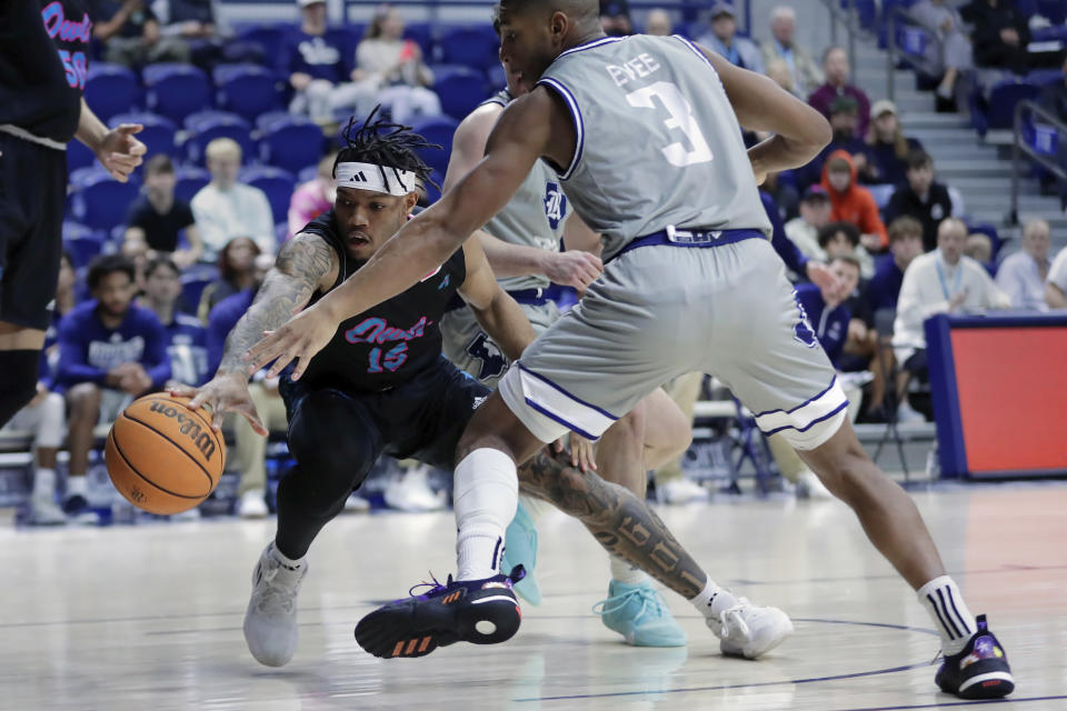 Florida Atlantic guard Alijah Martin, left, lunges for the ball headed out of bounds as Rice guard Travis Evee (3) reaches as well during the first half of an NCAA college basketball game Wednesday, Jan. 24, 2024, in Houston. (AP Photo/Michael Wyke)