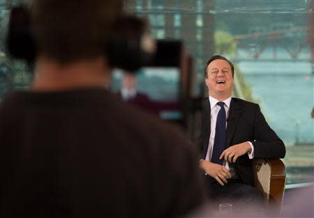 Britain's Prime Minister David Cameron laughs as he appears on the BBC's Andrew Marr Show, on the first day of the of the Conservative Party annual conference in Manchester, northern England September 29, 2013. REUTERS/Stefan Rousseau/Pool