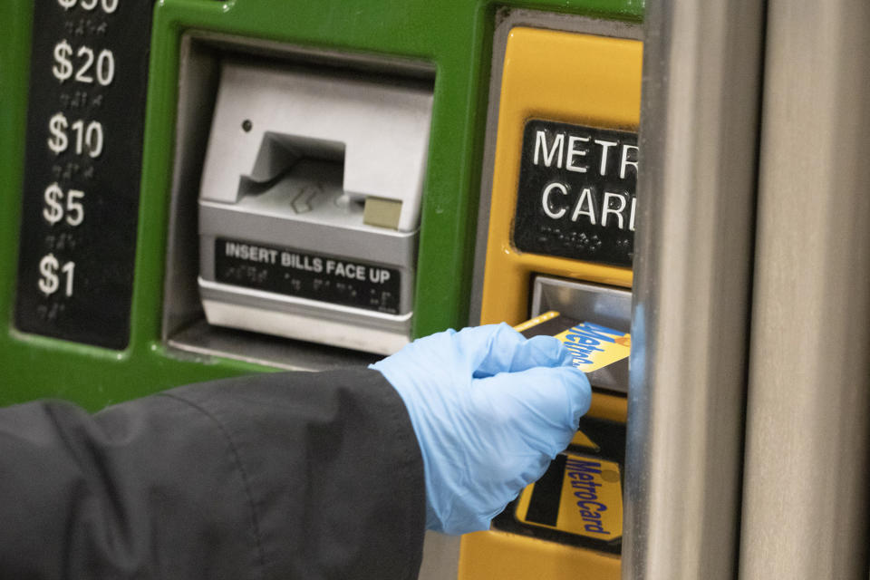 A woman wears a protective glove as she purchases a metro card at a subway station, Wednesday, March 4, 2020, in New York. She said that she always wears gloves in the subway "because it's filthy." According to the Centers for Disease Control and Prevention, (CDC), "It may be possible that a person can get COVID-19 by touching a surface or object that has the virus on it and then touching their own mouth, nose, or possibly their eyes, but this is not thought to be the main way the virus spreads." (AP Photo/Mark Lennihan)