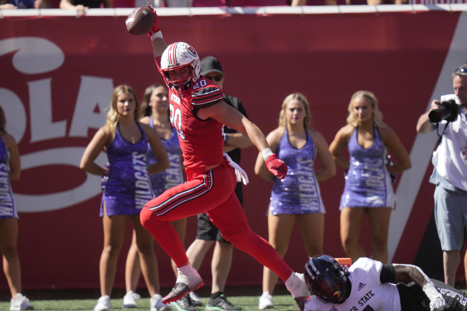 Utah linebacker Lander Barton (20) returns an interception for a touchdown as Weber State running back Kris Jackson, right, dives in during the second half of an NCAA college football game Saturday, Sept. 16, 2023, in Salt Lake City. (AP Photo/Rick Bowmer)