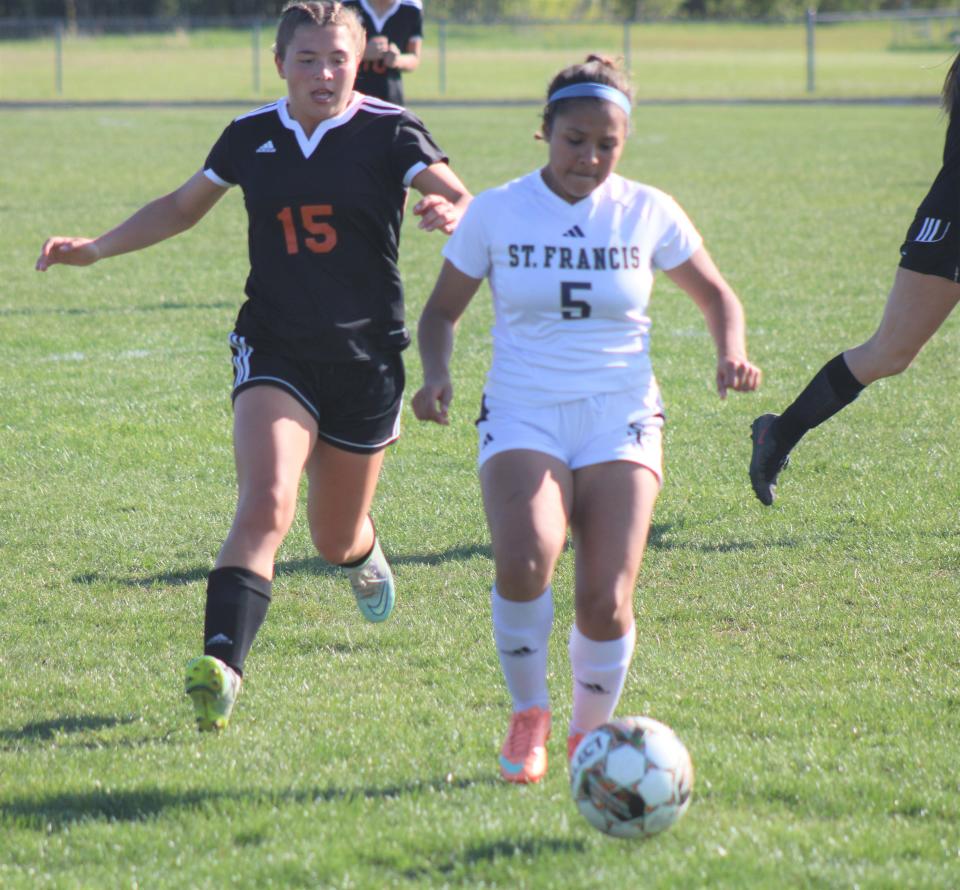 Cheboygan senior midfielder Cassidy Jewell (15) chases down Traverse City St. Francis' Cici Pedroza (5) during the second half of a MHSAA Division 3 girls soccer district matchup in Cheboygan on Thursday.