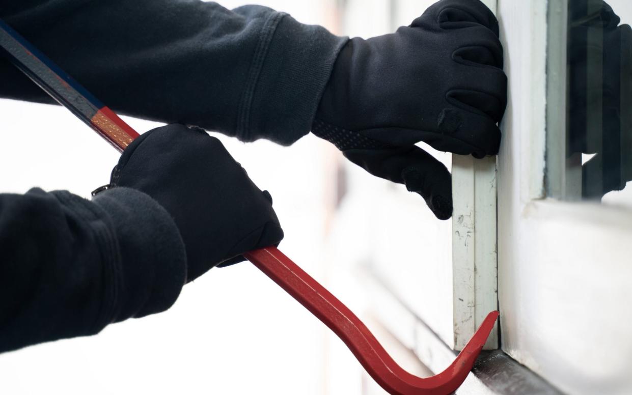Burglar trying to break into a house with a crowbar - Michael Deacon/GETTY IMAGES