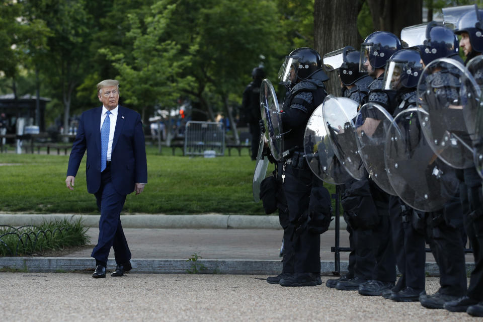 FILE - In this Monday, June 1, 2020, file photo President Donald Trump walks past police in Lafayette Park after visiting outside St. John's Church across from the White House in Washington. The violent clearing of demonstrators from the nation's premier protest space in front of the White House is spotlighting a tiny federal watch force created by George Washington. Democratic lawmakers want answers about the clubbing, punching and other force deployed by some Park Police in routing protesters from the front of the White House on Monday, (AP Photo/Patrick Semansky, File)