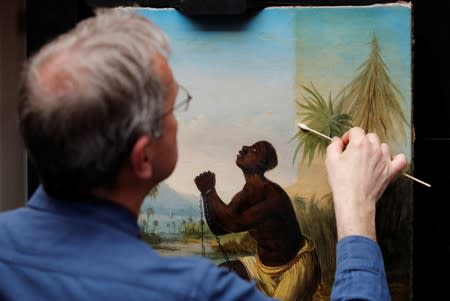 David Crombie, Senior Paintings Conservator at the National Museums, Liverpool carries out restoration work on the painting 'Am Not I A Man And A Brother', one of only 2 known paintings of its type in existence in Liverpool, Britain, July 30, 2019. Picture