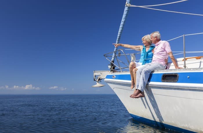 Senior couple on sailboat looking out at ocean