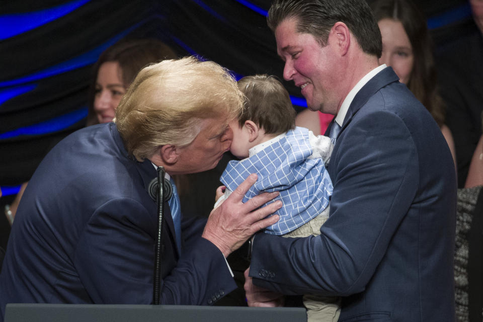 President Donald Trump kisses Hudson Nash, being held by father Andrew Nash, as Trump speaks about kidney health at the Ronald Reagan Building and International Trade Center, Wednesday, July 10, 2019, in Washington. (AP Photo/Alex Brandon)