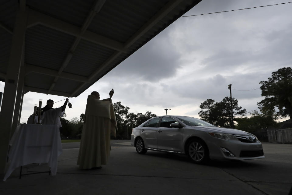 Fr. Steve Buno, Pastor of St. Rita of Cascia Catholic Church in Harahan, La., performs drive-thru Benediction of the Blessed Sacrament, as a form of social distancing due to the new coronavirus, during Holy Week, Tuesday, April 7, 2020. (AP Photo/Gerald Herbert)