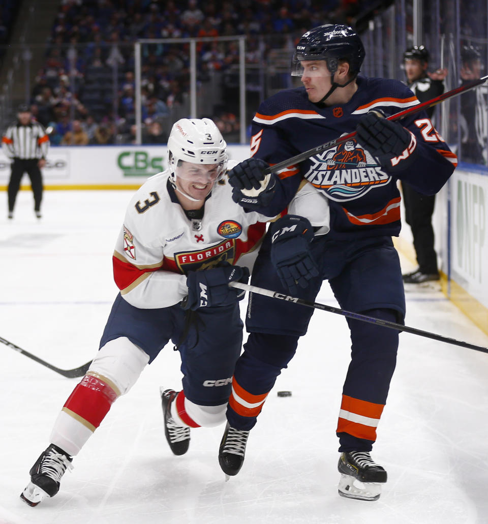 Florida Panthers defenseman Matt Kiersted (3) checks New York Islanders defenseman Sebastian Aho (25) during the second period of an NHL hockey game Friday, Dec. 23, 2022, in Elmont, N.Y. (AP Photo/John Munson)