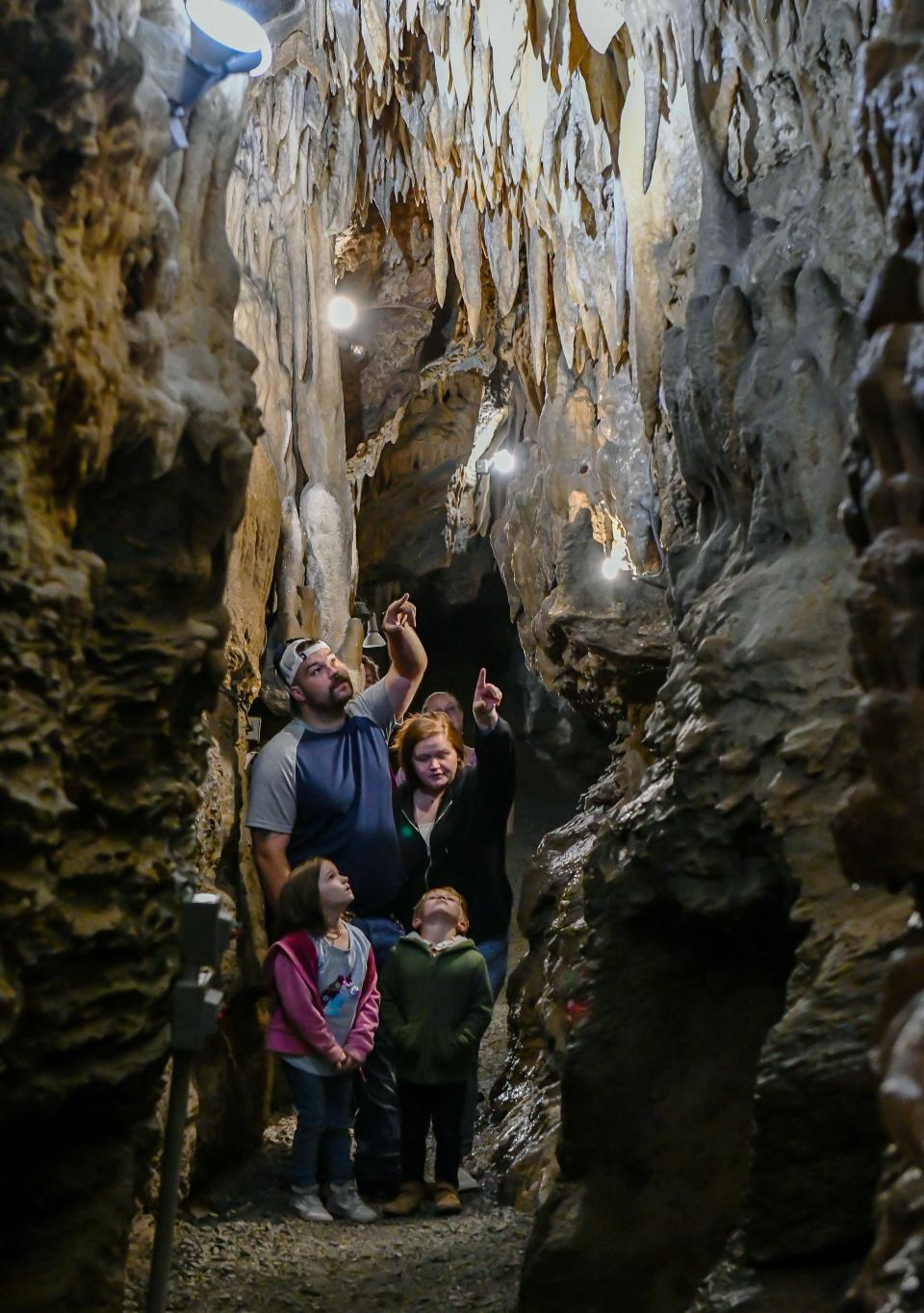 Ian and Mary Bridgers and their children, Mackenzie and Colton, look at the formations of calcite in Crystal Grottoes Caverns on Tuesday.