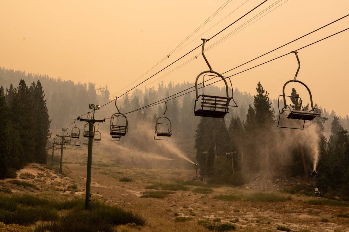 Snow-making machines spray water on the slopes of Heavenly Mountain Resort on the California-Nevada border near South Lake Tahoe while the Caldor Fire burns in 2021. People forced to flee the Lake Tahoe Basin during a wildfire emergency could face a life-threatening, hours-long, slog to safety, a new report reveals. Paul Kitagaki Jr./pkitagaki@sacbee.com