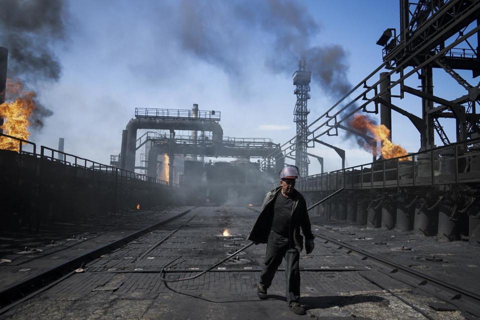 FILE In this Tuesday, Aug. 4, 2015 file photo a worker carries a metal rod at the front-line Avdiivka coking plant in eastern Ukraine. Fighting between government troops and separatist rebels in eastern Ukraine escalated on Tuesday, Jan. 31, 2017, killing several people overnight, injuring many more and trapping 200 coalminers underground, the warring sides reported. (AP Photo/Mstyslav Chernov, File)