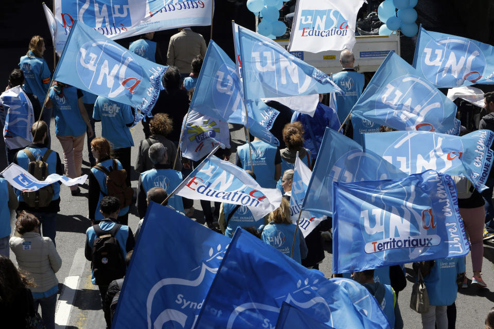 Public sector workers hold unions flags during a demonstration in Marseille, southern France, Thursday, May 9, 2019. French unions are holding strikes and protests against 120,000 job cuts and other deep changes to France's huge public sector by President Emmanuel Macron's government. (AP Photo/Claude Paris)