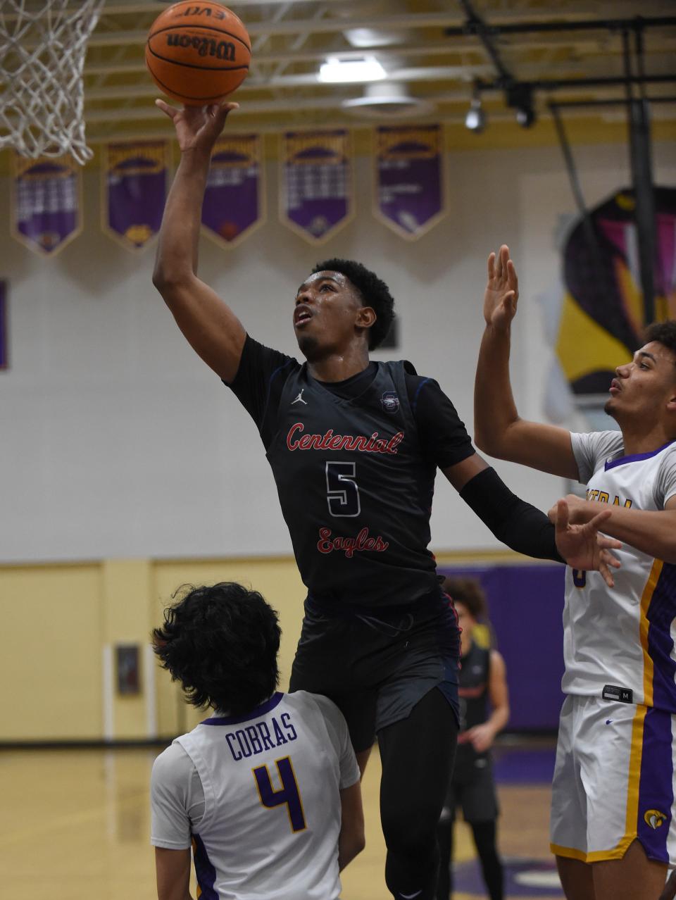 St. Lucie West Centennial's Joseph Lezeau tries a shot between Josh Banate (left) and Derrick King of Fort Pierce Central during the second half of their game inside Central's gym on Friday, Jan. 27, 2023 in Fort Pierce. Centennial won 65-56.