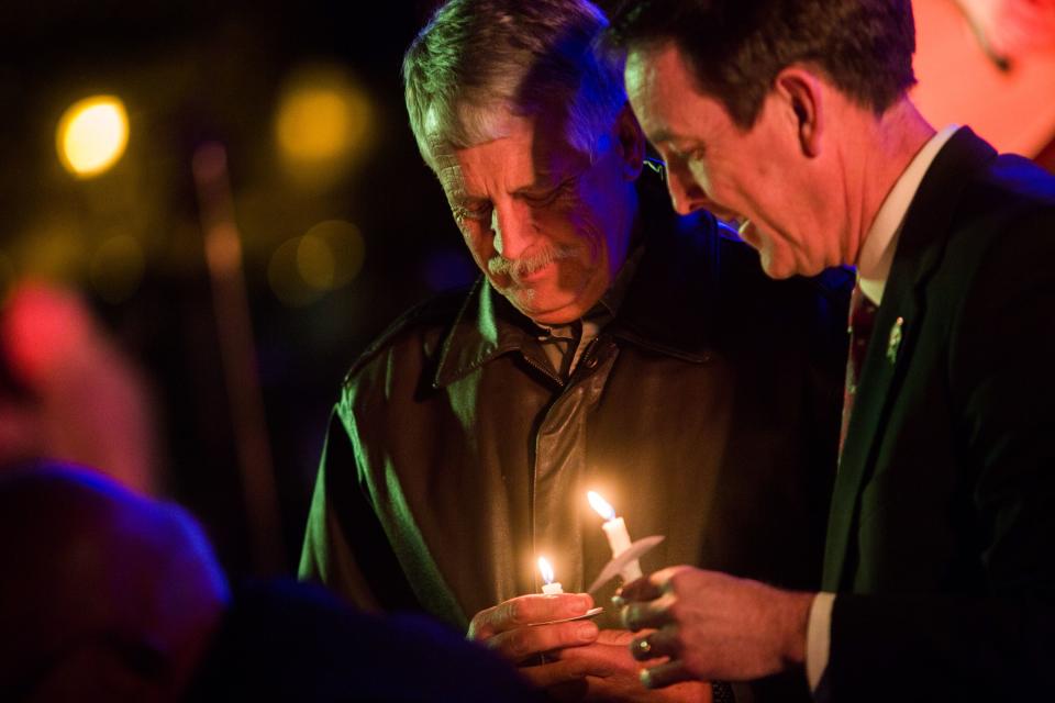 Carl Mueller holds his candle during a candlelight memorial honoring his daughter aid worker Kayla Mueller at the Prescott's Courthouse Square in Prescott, Arizona