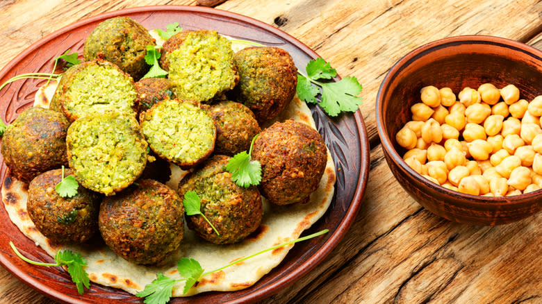 fried falafel balls with exposed interior on a plate on a wood surface