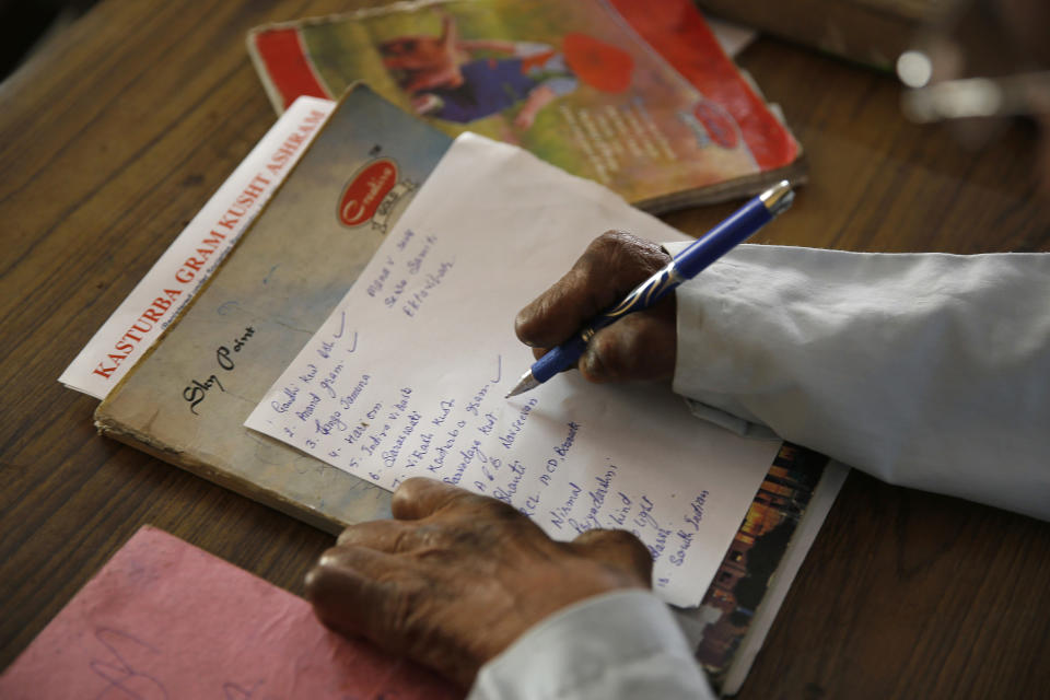 In this Feb. 16, 2014 photo, an Indian suffering from leprosy writes note in his office at a leper colony in New Delhi, India. Although India has made great strides against leprosy over the years, the stigma of the disease is as intractable as ever, hindering efforts to eliminate the disease entirely. Worldwide the number of new leprosy patients has dropped from around 10 million in 1991 to around 230,000 last year. Of these, 58 percent were to be found in India, according to the World Health Organization. (AP Photo/Manish Swarup)