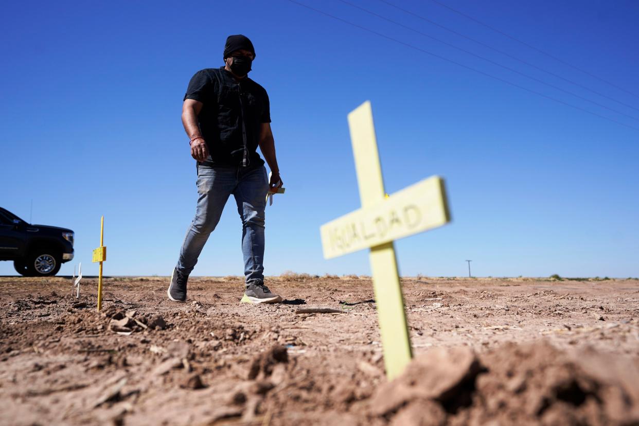 Hugo Castro leaves crosses at the scene of a deadly crash in Holtville, Calif. on Tuesday, March 2, 2021.