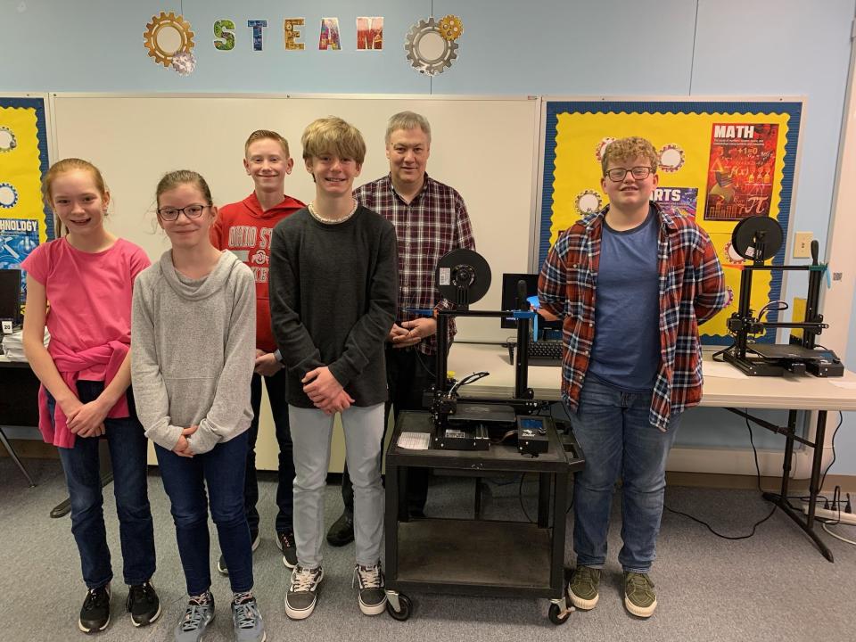Students Maddie Shenberger, (left to right) Alyssa Johnson, Jacob Gardner, Garrett Davis and Nathaniel Oblinger stand with teacher Mark LaGoy (back right) near one of the Ashland Christian School's 3D printers. The school plans to use the printers for a project that will be funded by Battelle and the Ohio STEAM Learning Network.