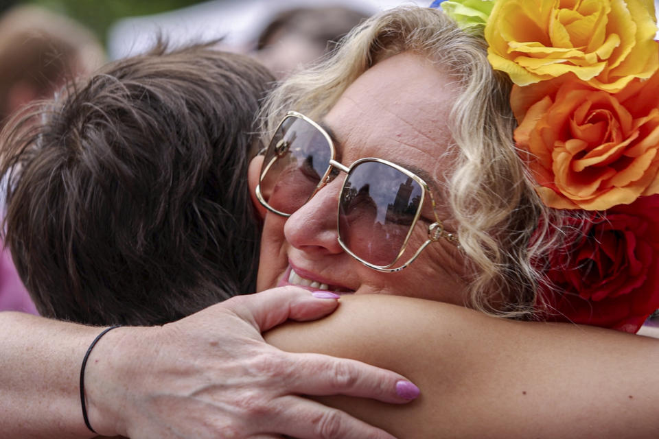 In an image captured from video, members of a group of Parents of LGBTQ+ children called "We, the Parents" hug youngsters taking part in Poland's yearly Pride parade, known as the Equality Parade, in Warsaw, Poland, on Saturday June 17, 2023. Parents of trans children are mobilizing in Poland seeking acceptance after the country’s leader mocked trans people last year during Pride season. Poland has been ranked as the worst country in the European Union for LGBTQ+ rights. (AP Photo/Michal Dyjuk)