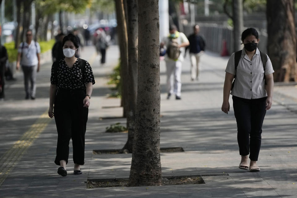 People wear masks as they walk at the main business district in Jakarta, Indonesia, on Oct. 3, 2023. Pollution is causing respiratory illnesses and deaths to rise in Indonesia's island of Java, including the capital, Jakarta. Data gathered by IQAir, a Swiss air technology company, regularly ranks Jakarta as one of the most polluted cities in the world. Blue skies are a rare sight and the air often smells like fuel or heavy smoke.(AP Photo/Achmad Ibrahim)