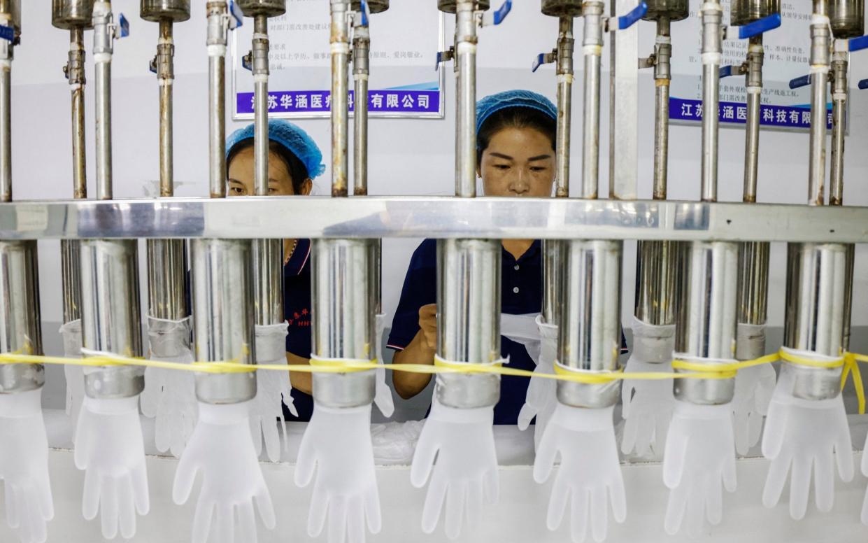 Workers on a PVC glove production line at a factory in Sihong, after China's industrial output slumped in August