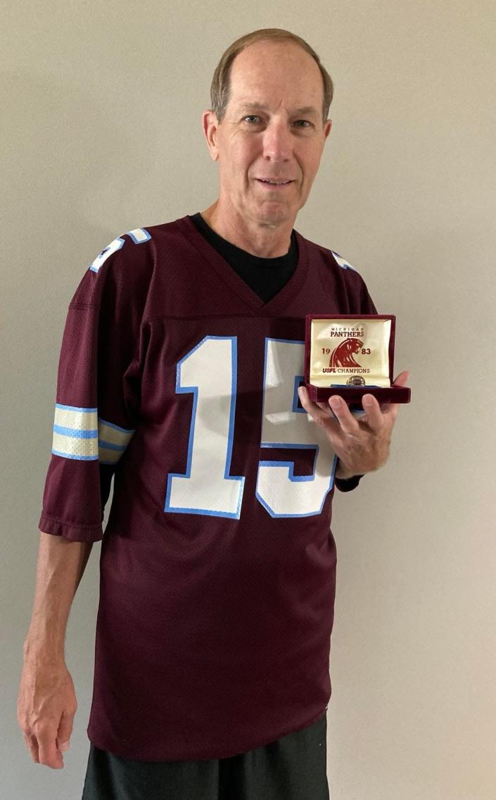Stark County resident Mark Miller, a former Canton South High School quarterback, wears his USFL Michigan Panthers jersey and displays his ring from the 1983 championship.