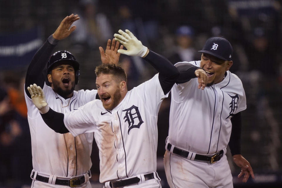 Detroit Tigers' Robbie Grossman is greeted bu Jeimer Candelario, left, and Miguel Cabrera after two-run walk-off home run during the 10th inning of a baseball game against the New York Yankees, Friday, May 28, 2021, in Detroit. (AP Photo/Carlos Osorio)