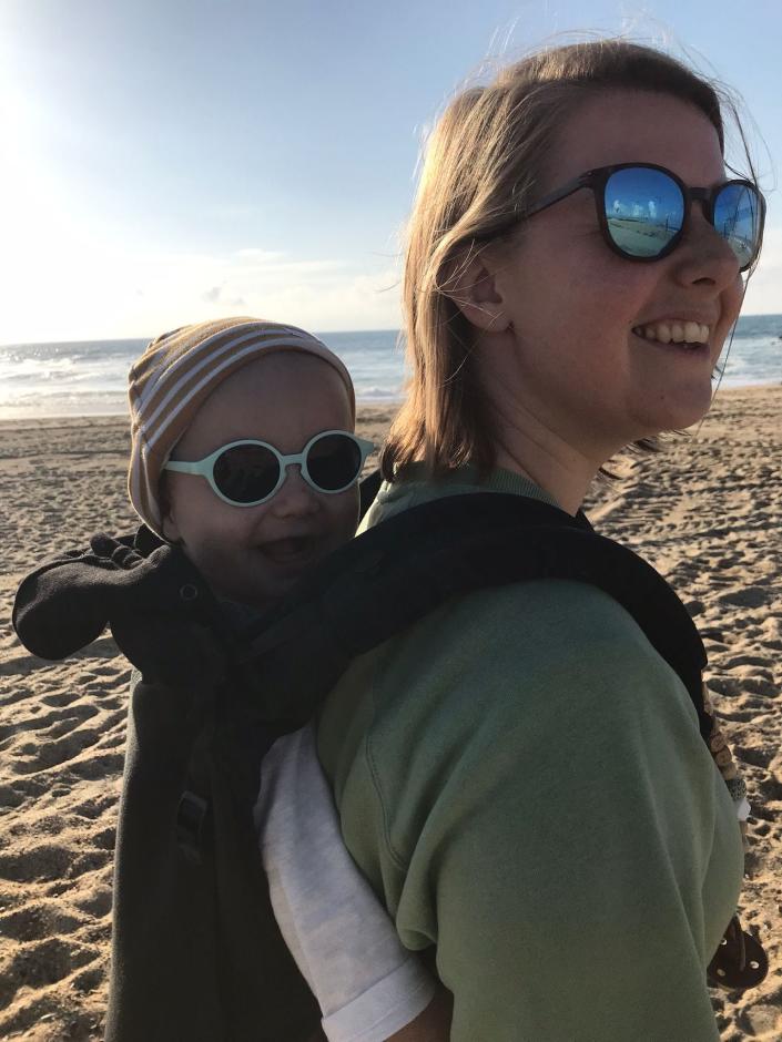 Anna and her son on a beach, both wearing sunglasses