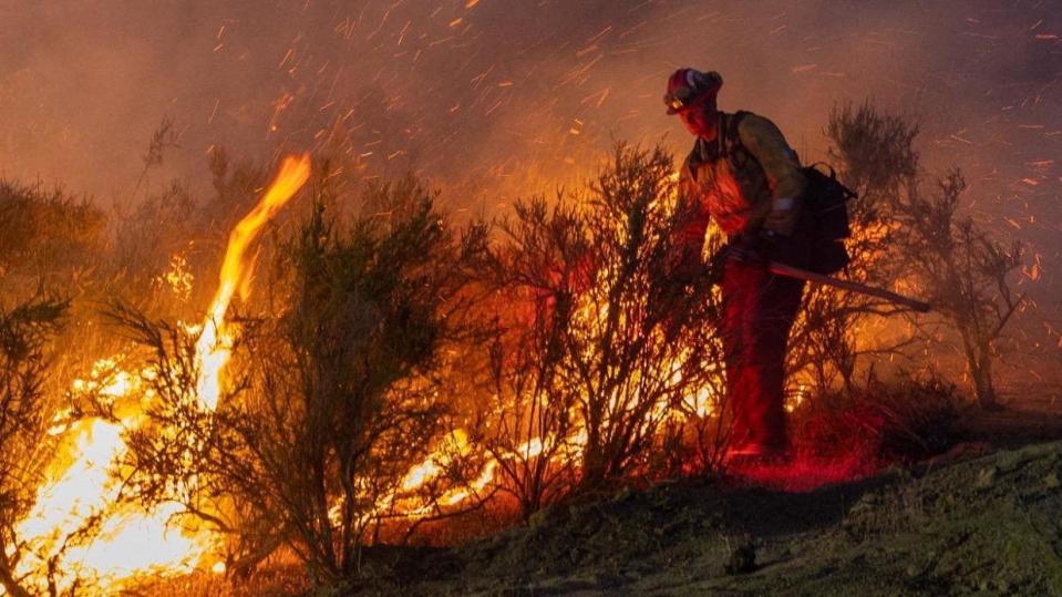 A firefighter battles the Sites fire near Lodoga, California, US, on Monday night