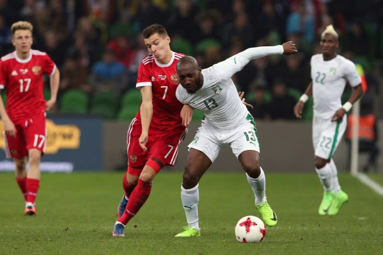 Russia's forward Dmitry Poloz and Ivory Coast's forward Giovanni Sio vie for the ball during their international friendly football match March 24, 2017