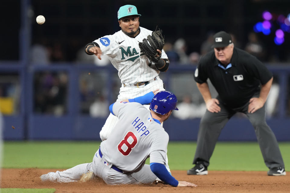 Miami Marlins second baseman Luis Arraez (3) tags Chicago Cubs' Ian Happ (8) and throws to first base to complete the double play during the sixth inning of a baseball game, Friday, April 28, 2023, in Miami. (AP Photo/Marta Lavandier)