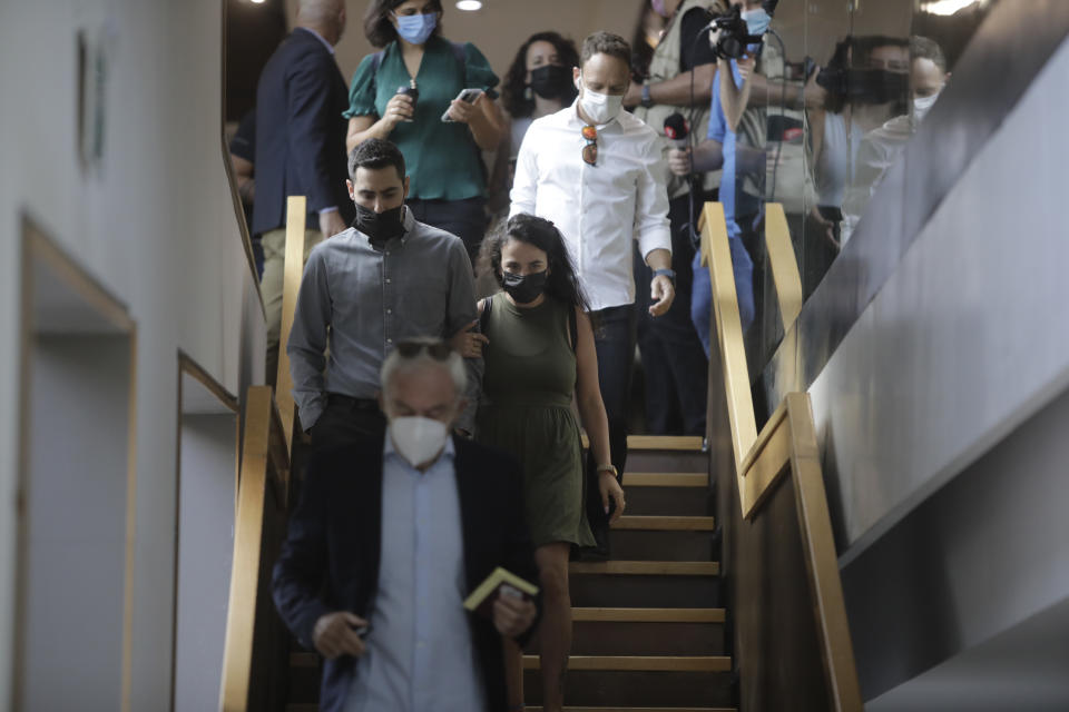 Gali Peleg, center, maternal aunt of Eitan Biran, who survived a cable car crash in Italy that killed his immediate family, arrives to court in Tel Aviv on Thursday, Sept. 23, 2021 for a hearing in the alleged kidnapping of her nephew. The boy's parents and younger sibling were among 14 killed in May when a cable car slammed into a mountainside in northern Italy. He is now the focus of a custody battle between his maternal grandparents in Israel and his paternal relatives in Italy. (AP Photo/Sebastian Scheiner)