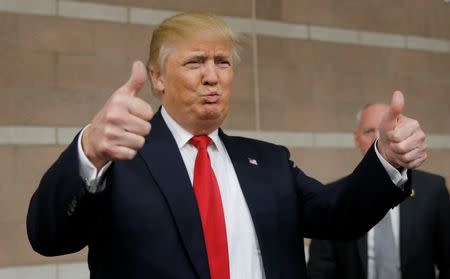 Republican U.S. presidential candidate Donald Trump gives thumbs up to caucus goers as he visits a Nevada Republican caucus site at Palo Verde High School in Las Vegas, Nevada February 23, 2016. REUTERS/Jim Young